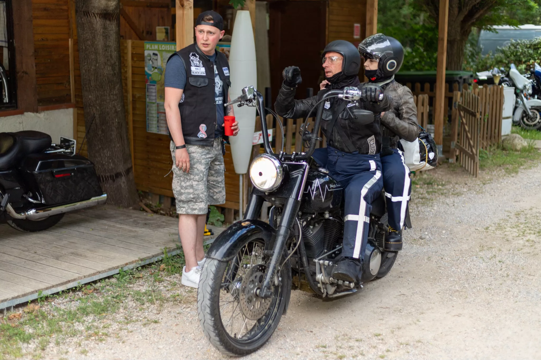 Deux bikers sur une moto demandant un renseignement à un autre biker